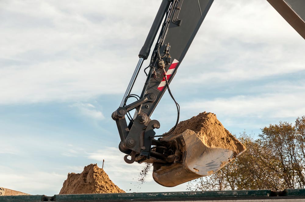 Grävskopa med jord i skopan